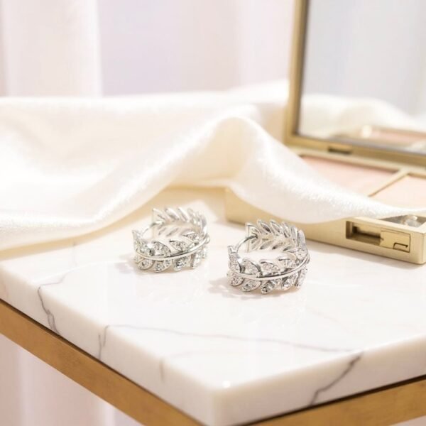 The Alloro Earrings are a refined expression of Italian heritage and timeless beauty. Inspired by the laurel wreath—an ancient symbol of victory and honor—these earrings are crafted with delicate leaf motifs and shimmering stones. Available in both gold-plated and silver finishes, they bring a graceful balance of classic design and modern sparkle. Perfect on their own or paired with the matching Alloro Ring, they embody elegance and strength for every occasion.