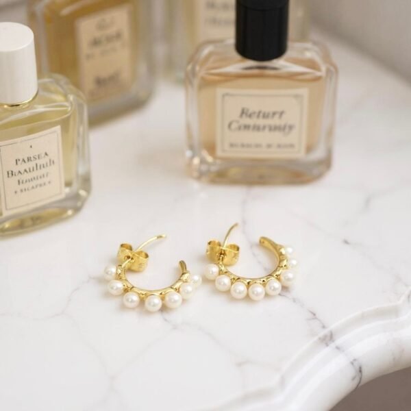 The Mezza Luna earrings capture the serene beauty of the moon in a delicate gold-plated half-hoop design. Adorned with a row of luminous pearls, these earrings are a graceful balance of simplicity and refinement. Their versatile style makes them the perfect choice for both everyday elegance and special occasions.
