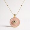 The Occhio Rosa and Occhio Bianco necklaces combine timeless tradition with modern elegance. Handcrafted with shimmering mother-of-pearl mosaics in soft blush pink or luminous white, each pendant features a sapphire-blue centerpiece surrounded by sparkling crystals — symbolizing the ancient talisman of the “evil eye.” Set in gold-plated detailing, these pendants are not only radiant accessories but also protective charms, believed to ward off negative energy while elevating any look