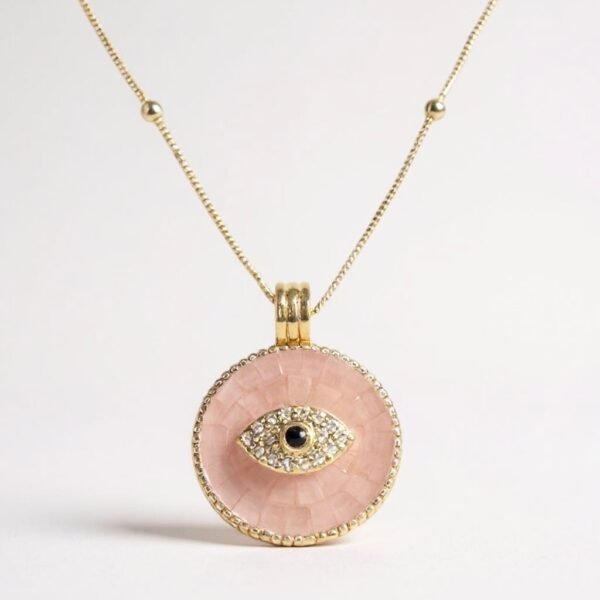 The Occhio Rosa and Occhio Bianco necklaces combine timeless tradition with modern elegance. Handcrafted with shimmering mother-of-pearl mosaics in soft blush pink or luminous white, each pendant features a sapphire-blue centerpiece surrounded by sparkling crystals — symbolizing the ancient talisman of the “evil eye.” Set in gold-plated detailing, these pendants are not only radiant accessories but also protective charms, believed to ward off negative energy while elevating any look