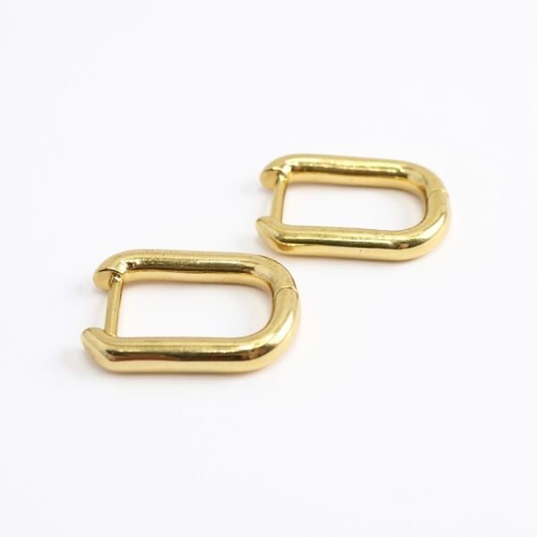 The Oro Puro earrings embody sleek sophistication with their minimalist rectangular hoop silhouette in high-polished gold-plated finish. Designed for those who love understated elegance, these versatile earrings transition seamlessly from day to night, adding a refined edge to any look. Their lightweight design ensures comfort, while their timeless finish makes them a staple piece for your jewelry collection.
