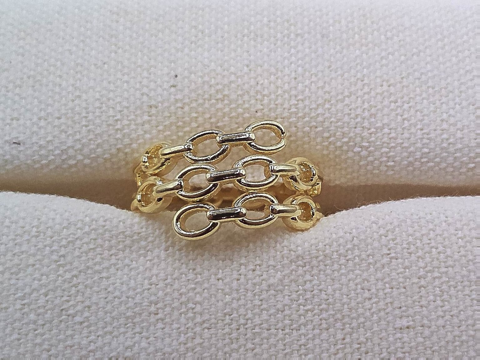 Gold chain-link style band ring with interlocking oval links.