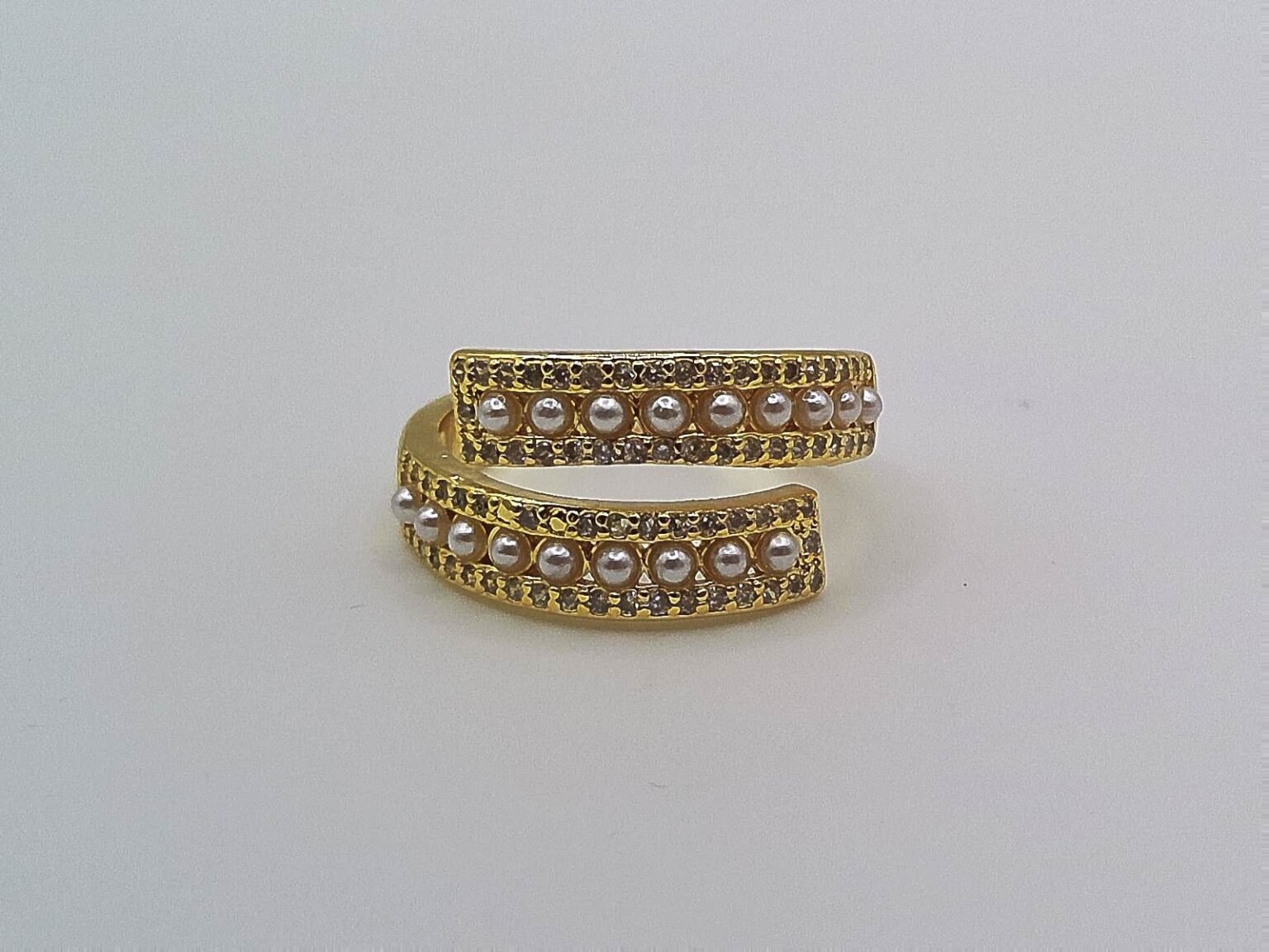 Gold wrap ring accented with small white pearls along two parallel bands.