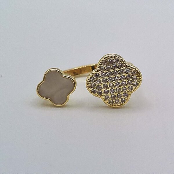 Gold open band ring with a white enamel clover on one end and a crystal-encrusted clover on the other.