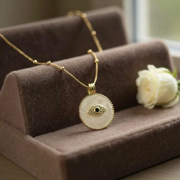 The Occhio Rosa and Occhio Bianco necklaces combine timeless tradition with modern elegance. Handcrafted with shimmering mother-of-pearl mosaics in soft blush pink or luminous white, each pendant features a sapphire-blue centerpiece surrounded by sparkling crystals — symbolizing the ancient talisman of the “evil eye.” Set in gold-plated detailing, these pendants are not only radiant accessories but also protective charms, believed to ward off negative energy while elevating any look.