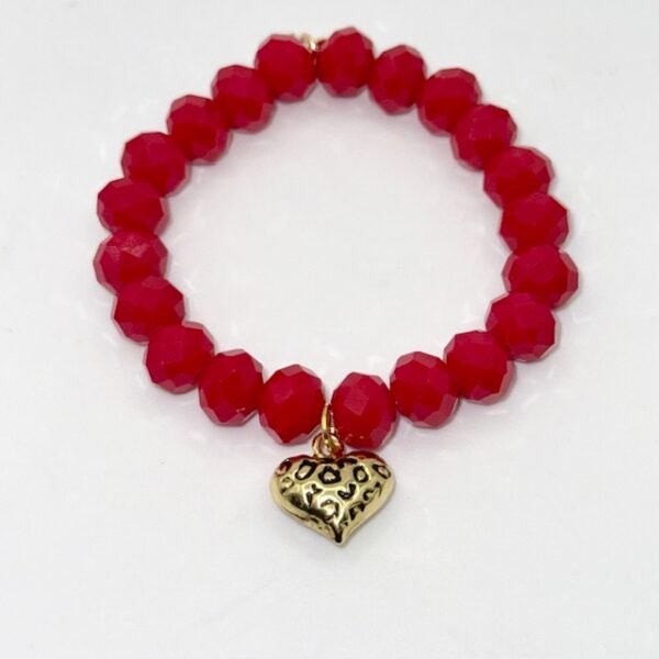 The Angalia Cuore bracelet is handcrafted with luminous red facted crystal beads, finished with a gleaming gold-plated heart charm etched in leopard detail. A radiant symbol of fierce love and fearless style, this bracelet is designed to catch the light and elevate any look. Whether worn solo as a statement piece or stacked for extra drama, Angalia Cuore is elegance with an edge. This bracelet looks beautiful on its own but truly shines when stacked with the classic black beaded bracelet. The bold red and gold heart charm create a striking contrast when paired with black, making it perfect for day-to-night elegance.