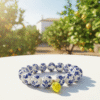 Fresh Elegance, Italian Charm. Infused with the zest and sunshine of Italy, the Limoncello Bracelet captures the joyful spirit of the Amalfi Coast. Featuring hand-painted blue and white floral ceramic-style beads accented with a vibrant lemon charm, this piece embodies both playful elegance and timeless Italian charm. Perfect on its own or stacked for a bold Mediterranean statement, Limoncello adds a refreshing touch of la dolce vita to any look.