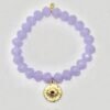 The Occhio Celeste bracelet radiates mystical beauty with faceted lavender crystals that capture light in every movement. At the heart of the bracelet hangs a gold-plated protective eye medallion with a radiant ruby-colored center, symbolizing clarity, intuition, and divine guidance. Whether worn solo for a touch of celestial elegance or stacked for bold expression, this bracelet serves as both a style statement and a talisman of light.