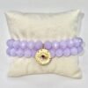 The Occhio Celeste bracelet radiates mystical beauty with faceted lavender crystals that capture light in every movement. At the heart of the bracelet hangs a gold-plated protective eye medallion with a radiant ruby-colored center, symbolizing clarity, intuition, and divine guidance. Whether worn solo for a touch of celestial elegance or stacked for bold expression, this bracelet serves as both a style statement and a talisman of light.