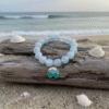 Inspired by the calming rhythm of the ocean, the Onda bracelet features soothing blue jade beads paired with a gold-plated ocean wave charm. This piece is more than just a beautiful accessory—it’s a symbol of hope and joy. A portion of proceeds from every Onda bracelet is donated to the Best Day Foundation, a non-profit dedicated to helping children and young adults with special needs build confidence and have fun through adventure activities like surfing. Wear the Onda bracelet to show your love for the sea and your support for making every day the best day for someone in need.