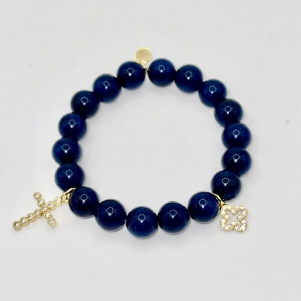 The Fede Blu Bracelet embodies timeless devotion and elegance. Crafted with deep blue polished beads, it symbolizes serenity and strength. Accented with two gold-plated charms—a sparkling pavé cross and a delicate quatrefoil—it represents faith, balance, and divine protection. Whether worn alone or stacked with complementary designs, this bracelet brings a touch of Italian sophistication and spiritual meaning to every moment. Pair the Fede Blu Bracelet with the Verde Classico Bracelet for a bold yet harmonious combination. The deep navy blue beads of Fede Blu reflect wisdom and strength, while the rich green tones of Verde Classico symbolize renewal and prosperity. Together, accented with gold-plated charms of faith and fortune, this stack becomes a powerful expression of balance, protection, and timeless Italian elegance. Wear them stacked for a statement look that transitions seamlessly from day to evening.