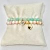 The Amore di Bellezza bracelet is designed as a symbol of devotion and elegance. Crafted with beads natural stone beads—choose from soft rose jade or calming green jade—each piece is accented with a delicate heart-shaped lock charm gold-plated or silver-toned. Sold individually, these bracelets are perfect on their own but even more striking when stacked together, allowing you to mix colors and finishes for a personalized statement of love and beauty.