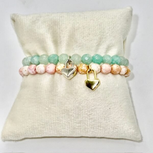 The Amore di Bellezza bracelet is designed as a symbol of devotion and elegance. Crafted with beads natural stone beads—choose from soft rose jade or calming green jade—each piece is accented with a delicate heart-shaped lock charm gold-plated or silver-toned. Sold individually, these bracelets are perfect on their own but even more striking when stacked together, allowing you to mix colors and finishes for a personalized statement of love and beauty.