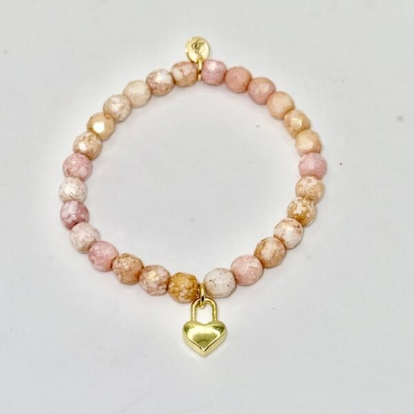 The Amore di Bellezza bracelet is designed as a symbol of devotion and elegance. Crafted with beads natural stone beads—choose from soft rose jade or calming green jade—each piece is accented with a delicate heart-shaped lock charm gold-plated or silver-toned. Sold individually, these bracelets are perfect on their own but even more striking when stacked together, allowing you to mix colors and finishes for a personalized statement of love and beauty.