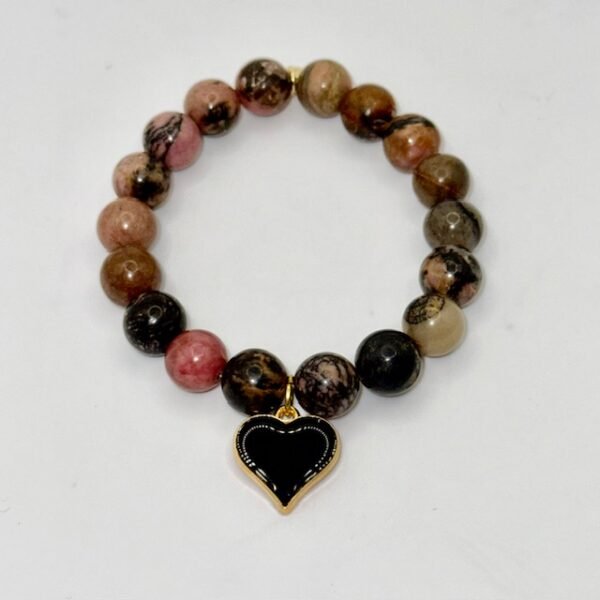 The Cuore di Terra bracelet combines the natural beauty of earthy Rhodonite stones with a striking black heart charm, symbolizing balance, protection, and enduring love. The grounding tones of brown, rose, and black reflect the richness of the earth, while the gold-plated-framed enamel heart adds a touch of modern elegance. Perfect on its own or stacked with crystal accents, this bracelet is a versatile piece that carries both strength and sophistication.