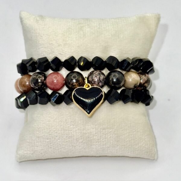 The Cuore di Terra bracelet combines the natural beauty of earthy Rhodonite stones with a striking black heart charm, symbolizing balance, protection, and enduring love. The grounding tones of brown, rose, and black reflect the richness of the earth, while the gold-plated-framed enamel heart adds a touch of modern elegance. Perfect on its own or stacked with crystal accents, this bracelet is a versatile piece that carries both strength and sophistication.