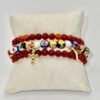 The Fede e Fortuna bracelet captures the essence of Italian tradition and protection. Crafted with hand-painted cloisonné beads in vibrant hues, accented with luminous pearls, and finished with symbolic gold-plated charms — a cross for faith and a cornicello for luck — this bracelet is more than an accessory; it’s a talisman of beauty, meaning, and heritage. Perfect for those who embrace both spiritual strength and good fortune in their journey. Wear it on its own as a statement of faith and fortune, or stack it with the deep red stone beaded bracelet to amplify its bold, passionate energy and create a truly striking layered look.