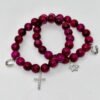 Embody faith and strength with our Cross Bracelet, crafted from rich magenta stones that radiate elegance and inner power. Accented with a delicate silver crystal-encrusted cross and a silver symbolic horseshoe charm, this bracelet blends timeless spirituality with a touch of fortune. A versatile piece that transitions seamlessly from everyday wear to special occasions, it’s designed to be both a symbol of devotion and a statement of style. Wear it solo as a bold expression of faith, or stack it with the green jade bracelet for a striking contrast that symbolizes balance, renewal, and protection.