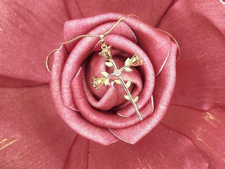 The Rosario Necklace beautifully intertwines devotion and nature’s elegance. Crafted in gold-plated, this pendant forms a cross made of delicate rose blooms, symbolizing love, faith, and eternal beauty. A sparkling center stone adds a touch of brilliance, making it both a meaningful keepsake and a timeless accessory. Perfect for those who want to carry faith and grace close to their heart.