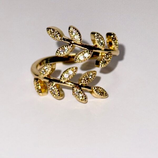Gold wrap ring designed with two branches of crystal-studded leaves.