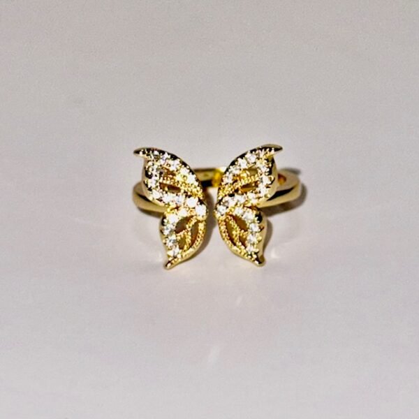 Gold ring shaped like a butterfly with wings encrusted in crystals.