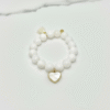 The Luna bracelet captures the serene beauty of the moon with luminous white beads, accented by a heart-shaped mother-of-pearl charm set in gold-plated detail. Symbolizing purity, love, and timeless grace, this piece is a reminder of the gentle light that guides us even in the darkest nights. Perfect on its own or paired with Rosalina for an ethereal, celestial stack.