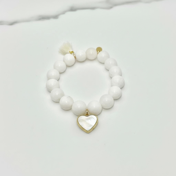 The Luna bracelet captures the serene beauty of the moon with luminous white beads, accented by a heart-shaped mother-of-pearl charm set in gold-plated detail. Symbolizing purity, love, and timeless grace, this piece is a reminder of the gentle light that guides us even in the darkest nights. Perfect on its own or paired with Rosalina for an ethereal, celestial stack.