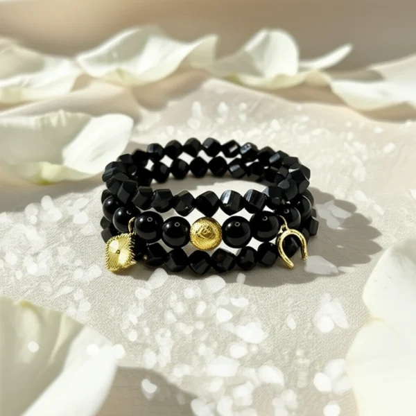 The Fortuna Nera bracelet is a striking symbol of fortune, strength, and style. Designed with smooth black onyx beads, it features radiant gold-plated charms — a delicate quatrefoil for luck, a textured orb for resilience, and a horseshoe for prosperity. Together, they create a talisman that’s both meaningful and fashion-forward. Versatile enough to wear from day to night, Fortuna Nera adds a touch of bold sophistication to any look. Whether stacked with other pieces or worn solo, it’s a timeless reminder that luck favors the bold.