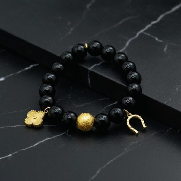 The Fortuna Nera bracelet is a striking symbol of fortune, strength, and style. Designed with smooth black onyx beads, it features radiant gold-plated charms — a delicate quatrefoil for luck, a textured orb for resilience, and a horseshoe for prosperity. Together, they create a talisman that’s both meaningful and fashion-forward. Versatile enough to wear from day to night, Fortuna Nera adds a touch of bold sophistication to any look. Whether stacked with other pieces or worn solo, it’s a timeless reminder that luck favors the bold.