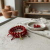 Channel centuries of Italian tradition with the Corno & Mano Fortuna Bracelet. Crafted with bold red marbled beads, this striking bracelet features two of the most powerful amulets of protection: the red cornicello (Italian horn) to ward off envy and misfortune, and the Mano Cornuto (horned hand) charm in silver or gold to shield against the evil eye. Together, they create a timeless talisman of resilience, passion, and luck. Designed to be unisex, this bracelet blends symbolic heritage with modern elegance—perfect for anyone seeking both style and strength in everyday wear.