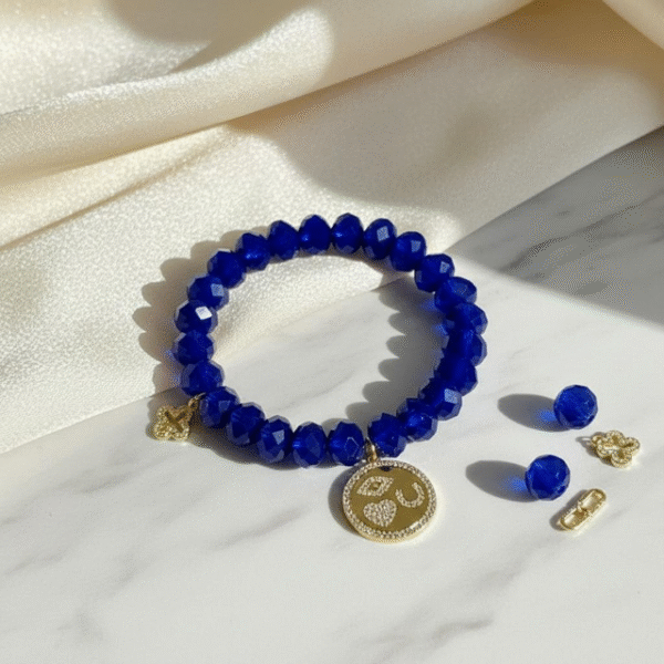 The Sapphire Amore Bracelet shines with vibrant faceted sapphire-blue crystals beads paired with radiant gold-plated charms. At its heart is a round medallion encrusted with pavé crystals, featuring timeless Italian symbols—the protective eye, the heart of love, and the horseshoe of luck. A delicate quatrefoil charm adds an extra touch of faith and elegance. This bracelet embodies Bella Pia’s signature blend of beauty and meaning, making it a versatile piece for both everyday wear and special occasions.