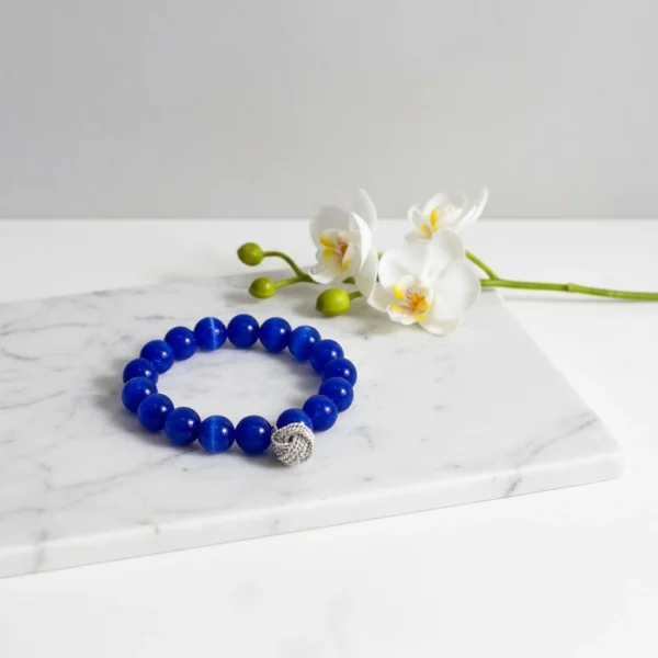 The Nodo D&G Bracelet is a heartfelt tribute to the unbreakable bond between mother and sons. Handcrafted with radiant sapphire-blue stones, it radiates strength, clarity, and devotion. At its center rests a beautifully detailed silver knot charm — a timeless symbol of connection, loyalty, and love that can never be undone. Whether worn as a daily reminder of cherished family ties or as a statement of elegance, Nodo D&G embodies both meaning and style. A piece that moves seamlessly from casual wear to evening elegance, it’s more than jewelry — it’s a story of family, heritage, and devotion.