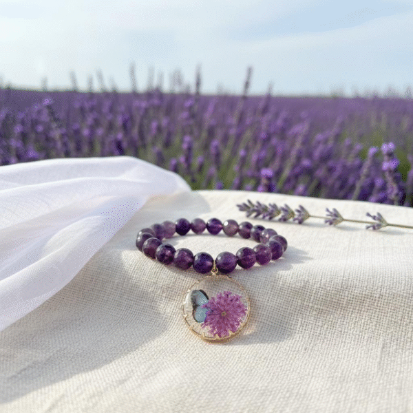 The Fiore di Speranza bracelet is a symbol of hope, healing, and transformation. Handcrafted with radiant amethyst beads, each stone carries calming and spiritual energy, long associated with clarity, protection, and peace. The design is elevated by a stunning pendant featuring a delicate pressed lavender flower and butterfly motif, celebrating the beauty of nature and renewal of the soul. More than a bracelet, it is a wearable reminder to embrace hope and cherish life’s meaningful moments. With every purchase, a portion of the proceeds is donated to the Stephanie Nicole Parze Foundation, supporting their vital mission to spread awareness, advocacy, and healing for those affected by domestic violence and abuse.