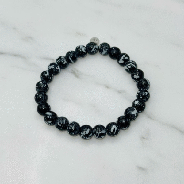 The Fortezza bracelet embodies grounded strength and refined style. Designed with striking black Obsidian beads naturally patterned in unique white-gray markings, each piece is truly one of a kind. Known as a stone of protection and balance, Obsidian supports clarity and inner resilience, making this bracelet a meaningful accessory for everyday wear. Its bold monochrome palette ensures it transitions effortlessly from casual to formal, offering strength and elegance in every moment.