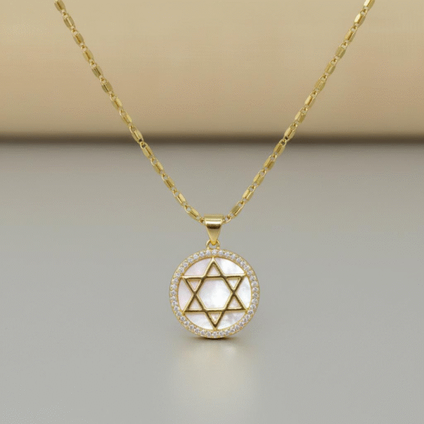 The Stella di Luna Necklace is a radiant tribute to the Star of David, crafted in luminous gold plating with a lustrous mother-of-pearl inlay. The six-pointed star — a timeless symbol of faith, protection, and divine balance — is encircled with a halo of sparkling crystals, reflecting moonlit brilliance. Designed to capture both elegance and meaning, this necklace celebrates heritage while exuding modern sophistication. Whether worn as a statement of devotion or a keepsake of tradition, it shines with enduring beauty.