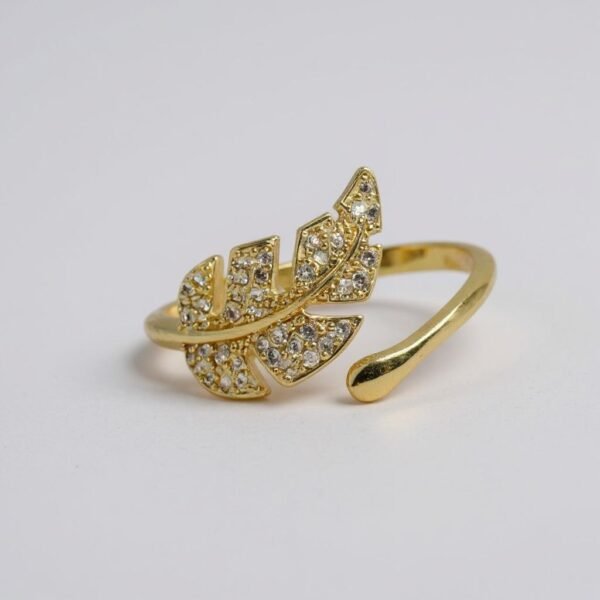 The Foglia Dorata Ring captures the delicate beauty of nature in a fashion-forward design. Crafted in gold-plated brass, this adjustable ring showcases a sparkling pavé crystal leaf that wraps gracefully around your finger. Its open band ensures a comfortable fit while adding a touch of modern sophistication. A perfect piece for layering or wearing solo, this ring embodies effortless glamour and everyday versatility. Whether worn casually or as a statement accessory, the Foglia Dorata Ring is a timeless expression of natural beauty elevated with radiant sparkle.