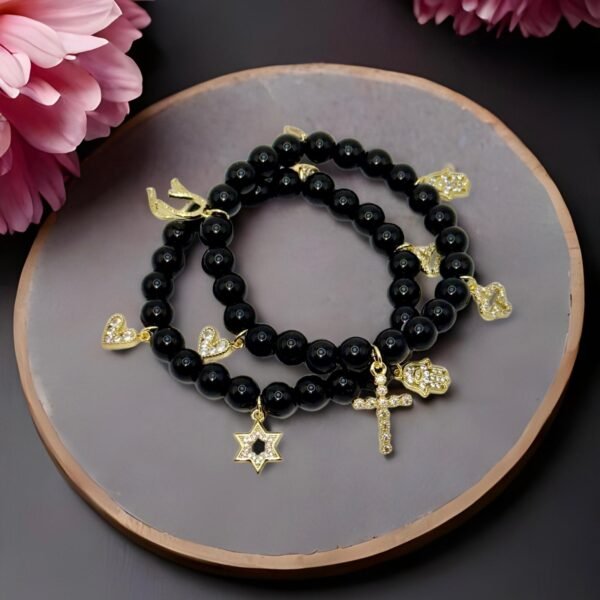 Step into protection and style with the Ginevra’s Amuleto Bracelet, a striking piece crafted with sleek black beads and adorned with radiant gold-plated charms. Featuring meaningful symbols—such as the cross, Star of David, heart, Hamsa hand, clover, and horseshoe—this bracelet celebrates spirituality, luck, and love all in one. Whether worn daily as a personal talisman or styled as a bold fashion statement, Ginevra’s Amuleto Bracelet is designed to keep positivity and elegance close to your wrist. A versatile piece for the woman who embraces both faith and fashion.