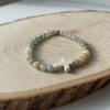 The Verde Serenità Bracelet is a calming symbol of faith and balance, handcrafted with soothing natural Amazonite stones. Known for their connection to emotional peace and inner harmony, these serene blue-green stones are beautifully paired with a white stone cross centerpiece—representing faith, guidance, and spiritual strength. Designed for both men and women, this bracelet embraces a minimalist earthy style that blends easily with everyday wear while holding a deeper meaning close to the heart. Whether worn alone or layered, it serves as a daily reminder of hope, purpose, and spiritual grounding.