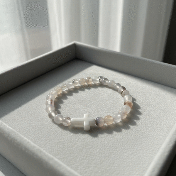 The Serenity Cross Bracelet is a minimalist expression of faith and inner peace. Handcrafted with smooth white agate gemstones, this bracelet embodies balance, grounding, and calm energy. At its center rests a sleek white cross bead, symbolizing guidance, hope, and divine protection. Its soft neutral palette makes it a beautiful and versatile accessory for both men and women, perfect for everyday wear, prayer, or meaningful gifting. Whether worn alone or stacked, it carries a message close to the heart—simple, spiritual, and sincere.