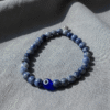 Discover effortless protection with the Azzuro Guard Bracelet—a modern take on ancient symbolism. Handcrafted with deep sapphire-blue sodalite stones, this bracelet represents clarity, intuition, and emotional balance. At its heart is the striking blue evil eye bead, a timeless symbol believed to shield against negativity and invite peace and good fortune. Versatile and powerful, this unisex bracelet transitions seamlessly from casual weekends to everyday wear. Whether worn alone or stacked, it’s a bold reminder to move through life with confidence and purpose.