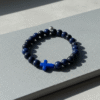 The Croce Azzurra bracelet blends bold faith with modern masculinity. Crafted with deep navy-blue natural stone beads and anchored by a striking azzurro (blue) cross, this piece carries purpose and power. The color blue symbolizes wisdom, protection, and confidence—making it more than just a bracelet, but a reflection of inner strength and belief. Designed for everyday wear, it elevates casual looks and pairs effortlessly with a watch or layered pieces. Whether you're stepping into the office, the gym, or a night out, Croce Azzurra keeps your faith close and your style sharp.