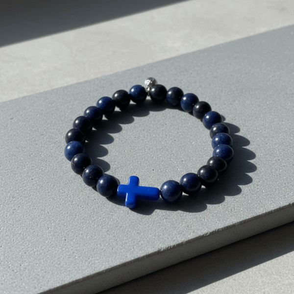 The Croce Azzurra bracelet blends bold faith with modern masculinity. Crafted with deep navy-blue natural stone beads and anchored by a striking azzurro (blue) cross, this piece carries purpose and power. The color blue symbolizes wisdom, protection, and confidence—making it more than just a bracelet, but a reflection of inner strength and belief. Designed for everyday wear, it elevates casual looks and pairs effortlessly with a watch or layered pieces. Whether you're stepping into the office, the gym, or a night out, Croce Azzurra keeps your faith close and your style sharp.