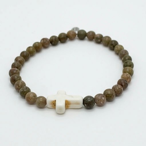 Grounded in natural beauty and spiritual meaning, the Croce Terra Bracelet blends earthy tones with a timeless symbol of faith. Handcrafted with natural jasper gemstone beads, each stone reflects the rugged beauty of nature and carries a grounding energy that inspires balance, courage, and calm. The bracelet is centered with a handcrafted white cross bead—an elegant reminder of faith and purpose. Designed for everyday wear, Croce Terra offers a minimalist style that pairs effortlessly with any look—casual, professional, or spiritual. Made with a comfortable stretch design to fit most wrists, it's perfect as a personal keepsake or a thoughtful gift of meaningful style.