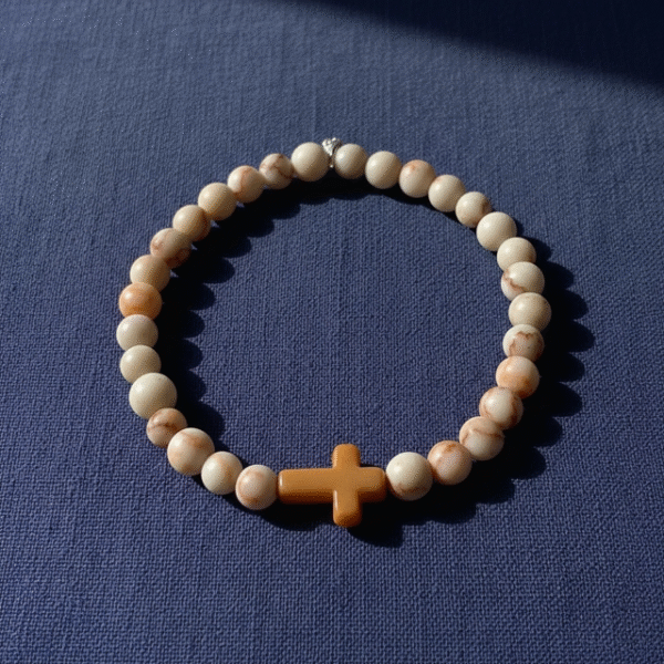 Inspired by the warm tones of sunlit desert sands, the Croce Sabbiosa Bracelet blends natural beauty with meaningful design. Featuring smooth cream-and-sand gemstone beads paired with a caramel-hued cross centerpiece, this bracelet brings a grounded, peaceful energy to everyday wear. Handcrafted with care, it’s a subtle yet powerful expression of faith, purpose, and style. The neutral palette makes it effortlessly versatile—perfect for both men and women who appreciate understated elegance with spiritual depth.