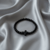 Embrace timeless simplicity with the Notte Nera bracelet, a unisex piece designed for those who value quiet strength and deep purpose. Handcrafted with polished black onyx beads and centered by a bold matte cross, this bracelet represents resilience, faith, and unwavering character. Its minimalist design makes it perfect for everyday wear—whether styled alone or stacked with other pieces. A reminder that true power speaks softly.