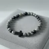 Discover refined faith with the Pietra di Fede bracelet. Designed for the modern man, this piece blends natural stone beads in bold shades of black, grey, and earthy tones with a sleek cross centerpiece. Each bead is uniquely patterned, making every bracelet one of a kind. Wear it as a daily reminder of direction, purpose, and grounded strength. Built on durable stretch cord for all-day comfort—casual enough for everyday wear, meaningful enough for moments that matter.