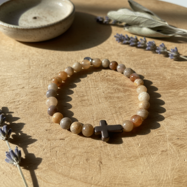 Embrace grounded elegance with the Sabbia Croce men’s bracelet, crafted from natural desert sandstone beads and centered with a bold hematite cross. Inspired by warm earth tones and timeless faith, this bracelet carries a calming, masculine presence—perfect for daily wear or layered with leather and steel for a rugged look. Stretch design ensures a comfortable fit while each bead offers a unique texture and natural grain, making every piece one of a kind. A meaningful symbol. A refined accessory. A personal reminder of strength and purpose.
