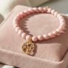 Handcrafted with genuine natural Rose Quartz gemstones and finished with a gold-plated Tree of Life charm, Fior di Sogni is a bracelet that celebrates love, healing, and inner peace. Known as the stone of unconditional love, Rose Quartz radiates calming energy and emotional harmony, while the Tree of Life symbolizes strength, growth, and connection. A meaningful piece of jewelry designed to empower the heart and elevate your style with a soft, romantic glow. Perfect for gifting—or cherishing for yourself.