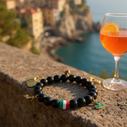 Celebrate your passion, personality, and Italian soul with Spirito Libero. This luxurious charm bracelet blends modern style with Italian heritage for a bold, expressive statement. Designed using polished black onyx beads—known for strength and grounding—it features premium gold-plated charms that tell a story of freedom, adventure, and unmistakable Italian flair. From the tricolor bead symbolizing Italia to unique charms like the Vespa scooter, stiletto heel, heart, and luxury handbag, every detail reflects la dolce vita—confidence, romance, and passion for life. Whether you're elevating your everyday style or honoring your roots, this bracelet is a masterpiece of personality.