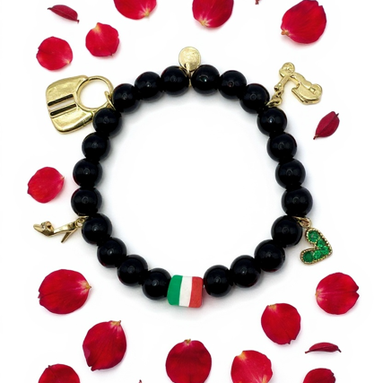 Celebrate your passion, personality, and Italian soul with Spirito Libero. This luxurious charm bracelet blends modern style with Italian heritage for a bold, expressive statement. Designed using polished black onyx beads—known for strength and grounding—it features premium gold-plated charms that tell a story of freedom, adventure, and unmistakable Italian flair. From the tricolor bead symbolizing Italia to unique charms like the Vespa scooter, stiletto heel, heart, and luxury handbag, every detail reflects la dolce vita—confidence, romance, and passion for life. Whether you're elevating your everyday style or honoring your roots, this bracelet is a masterpiece of personality.